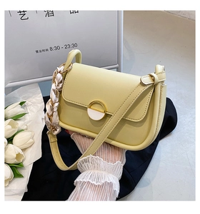 Détail du sac selle jaune clair avec poignée en ruban de soie et fermoir doré