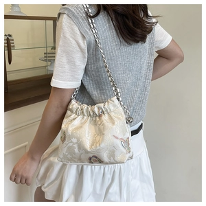 Detail of floral jacquard shoulder bag with butterfly patterns and silver chain strap
