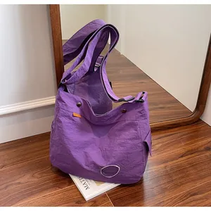 Dettaglio del resistente tessuto in nylon viola e tasca laterale di questa borsa tote