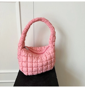 Detail of pink quilted cloud bag featuring soft padded fabric and zipper closure