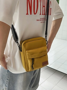 Yellow minimalist nylon crossbody phone bag for women with adjustable strap and front pocket