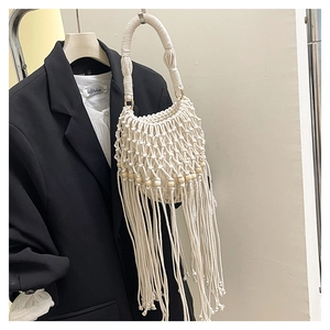 Detail of bohemian macrame handbag with hand-woven cream cotton ropes and wood beads