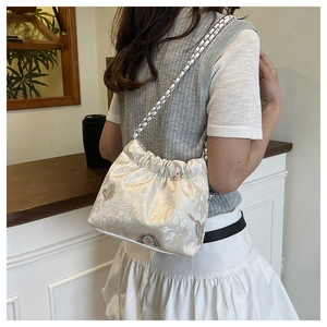 Detailed view of vintage embossed floral canvas bag with a silver chain shoulder strap