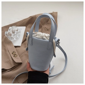 Detail of light blue lychee pattern bucket bag with white canvas drawstring liner
