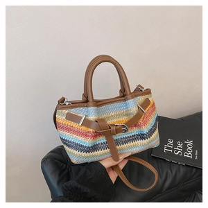 Detailed close-up of a colorful striped woven straw beach tote bag with brown leather handles