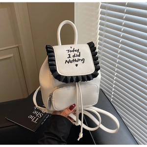 Close-up of white mini backpack with black ruffle trim and Today I did Nothing embroidery