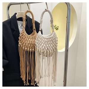 Detail of woven macramé bags featuring long tassels and decorative wooden beads
