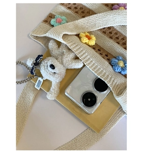 Détail du sac cabas tissé à rayures avec fleurs au crochet et breloque ours en peluche