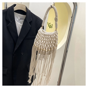 Detail of cream woven bohemian bag featuring wooden beads and long fringe tassels