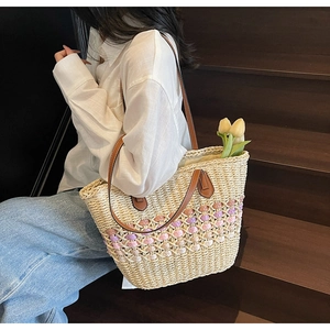 Sac fourre-tout en paille avec accents colorés et lanières en cuir sur modèle