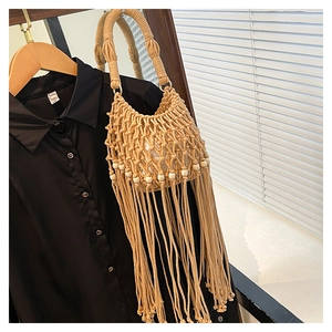 Detail of bohemian beige hand-woven tassel bag featuring wood beads and thick handles