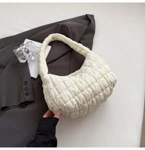 Detail of the quilted texture and soft padded handle on this cream puffy cloud bag