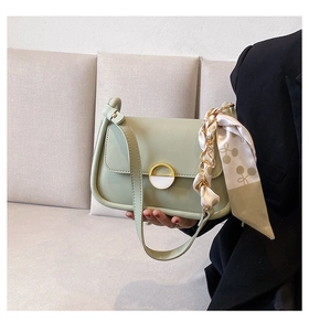 Détail du sac selle vert menthe avec foulard en soie cerise et boucle en anneau doré
