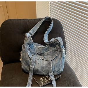 Detailed macro view of washed denim bag with vintage pockets and metal ring accents