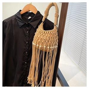 Detail of bohemian macramé handbag with long fringe and decorative wooden beads