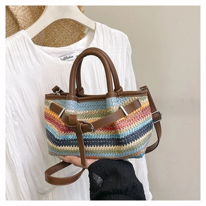 Detail of multi-color bohemian woven tote bag with brown leather handle and silver buckle