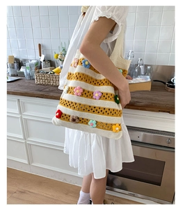 Détail du sac cabas en tricot à rayures jaunes avec fleurs au crochet colorées