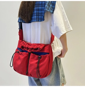 Detailed view of a red drawstring crossbody bag with cargo pockets on a model back