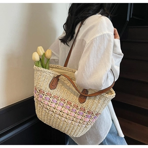 Détail du sac cabas en paille tressée avec motifs au crochet violets et anses en cuir