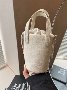 Chic beige bucket bag in pebbled leather with drawstring lining and top handle