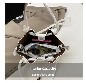 Top view showing the spacious interior of a white litchi pattern bucket bag with accessories