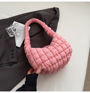 Detailed close-up of pink quilted puffer hobo bag with textured bubble fabric