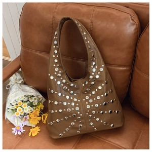 Detail of vintage brown Hobo bag featuring silver rivet starburst pattern on soft PU leather