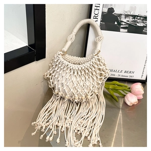 Detail of bohemian hand-woven tote bag featuring wooden beads and long cotton tassels