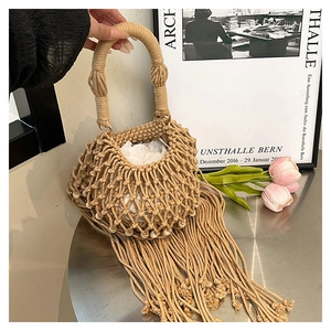 Detailed close-up of handmade bohemian woven bag with long tassels and beaded accents