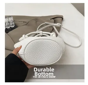 Detail shot of the durable base on a white pebble grain leather bucket handbag