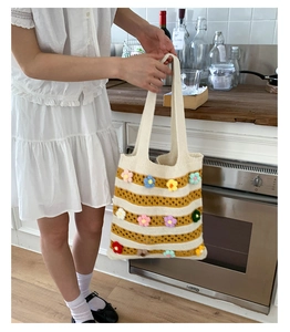 Detail of knitted tote bag with 3D crochet flowers and yellow striped texture
