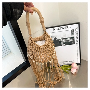 Detail of bohemian fringe bag with wooden beads and woven circular handle