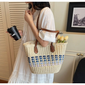 Détail du sac cabas en paille bohème montrant le tissage dégradé bleu et les anses cuir