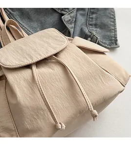Detail of beige canvas backpack with drawstring closure and soft wrinkled texture fabric