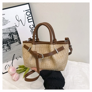 Close-up of the woven straw texture and premium brown faux leather trim on the tote bag