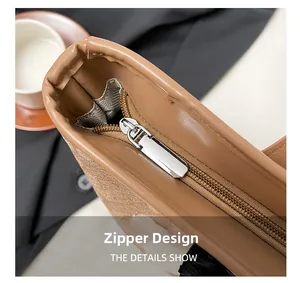 Macro shot of smooth zipper design on brown PU leather tote with striped lining detail