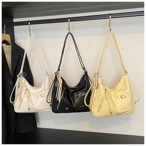 Detailed view of large textured hobo bags with tassel and metal buckle on hangers