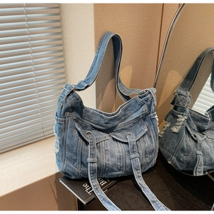 Detailed close-up of blue denim tote bag featuring stylish frayed edges and front pockets
