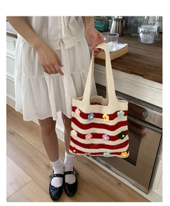 Detailed knit texture of large tote bag with colorful 3D flower crochet appliques