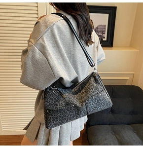 Detail of grey leopard print tote bag with silver studs and heart-shaped charm