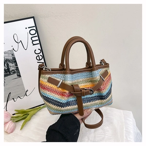 Detail of colorful striped woven tote with brown leather handles and decorative buckle