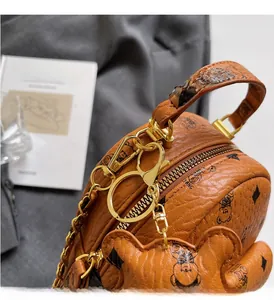 Detailansicht goldener Reißverschlüsse und Ketten am Mini-Lederrucksack mit Bären