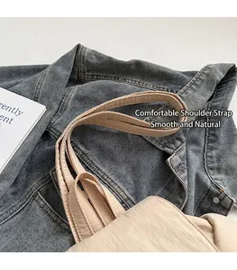 Detail of the wide comfortable shoulder strap on this beige canvas backpack for travel