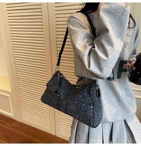 Detail of grey leopard print hobo bag with mini pouch and silver studs on shoulder strap