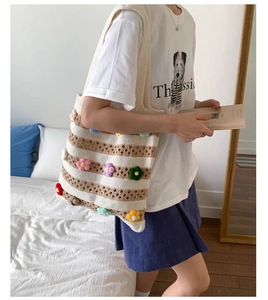 Détail du sac fourre-tout rayé avec décorations florales en tricot 3D colorées
