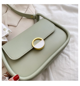 Gros plan du sac besace vert haricot avec boucle dorée et élégant ruban décoratif
