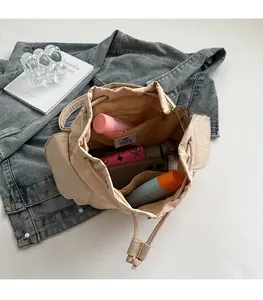 Top view of the spacious interior of a beige bucket bag with a zippered pocket