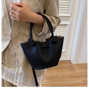 Detail of black lychee grain leather bucket bag with unique knotted rope handle for women