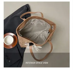 Detail view of large brown floral tote bag showing spacious interior and zip pocket