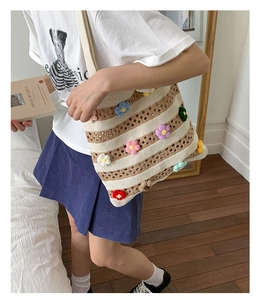 Gros plan sur un sac cabas au crochet à rayures avec détails de fleurs en relief